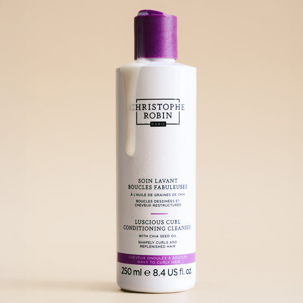 Bottle of Christophe Robin hair care product on a beige background
