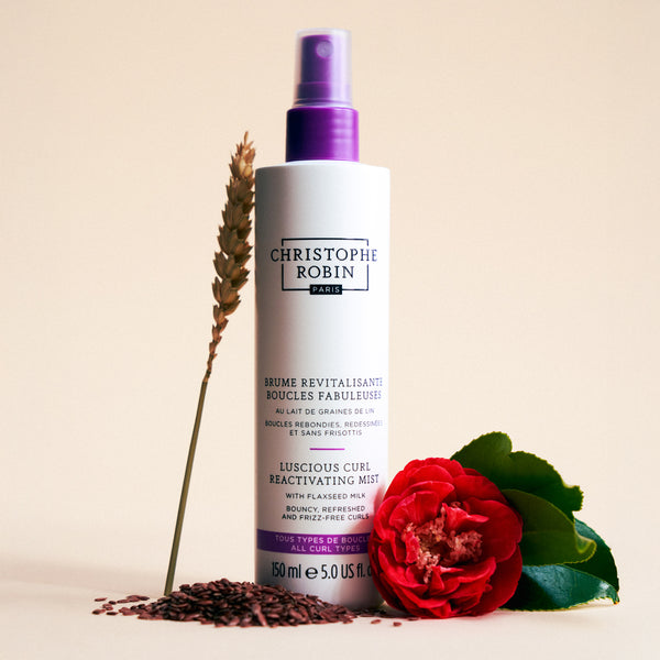 Christophe Robin hair mist bottle with a red rose and lavender on a beige background