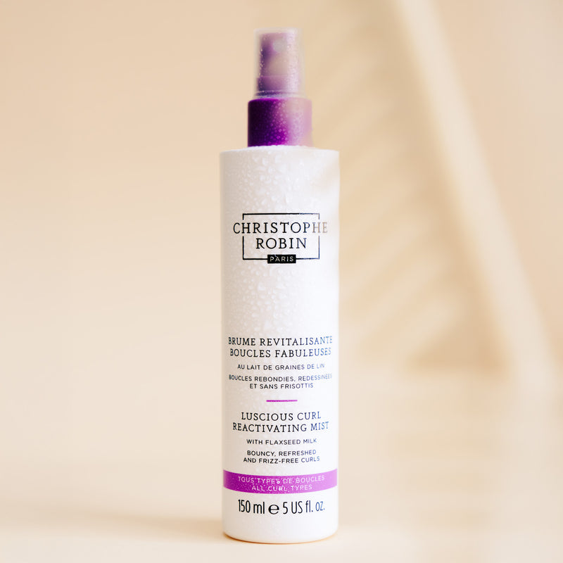 Bottle of Christophe Robin luscious curl mist product on a beige background