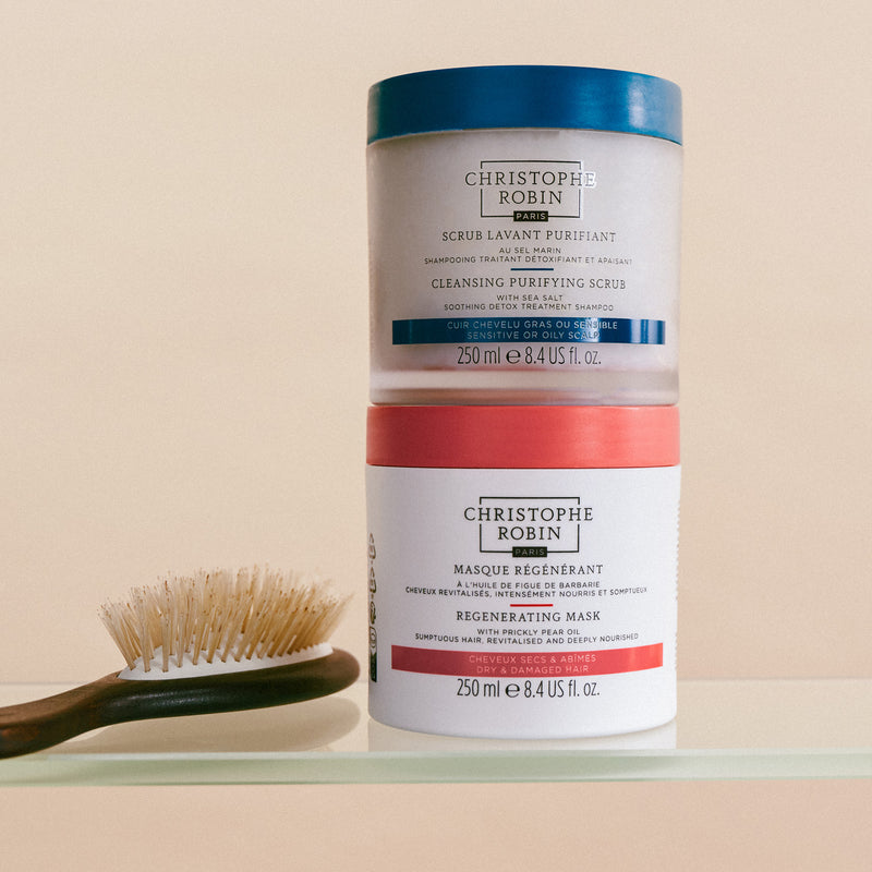 Christophe Robin cleansing purifying scrub and regenerating mask on beige background with hairbrush