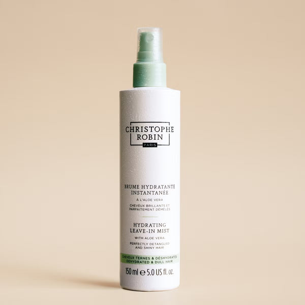 Bottle of Christophe Robin hydrating leave-in mist on a beige background