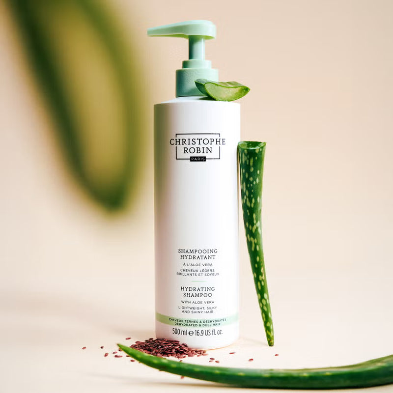 Christophe Robin shampoo bottle 500ml with aloe vera leaves on a beige background