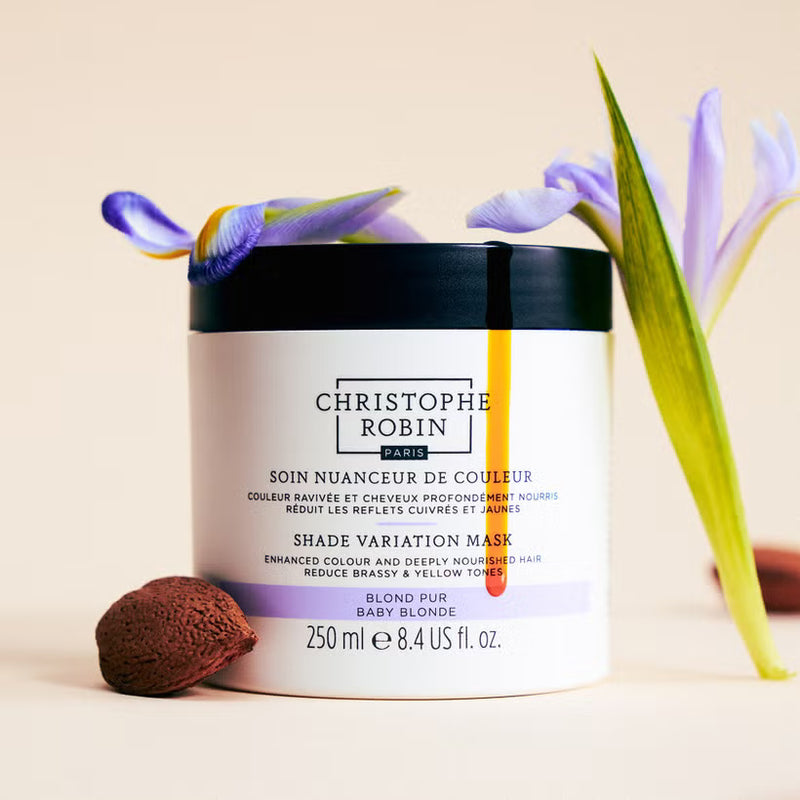 Christophe Robin  Shade variation hair mask jar in baby blonde variant with ingredients, iris flower and almond butter  on a beige background