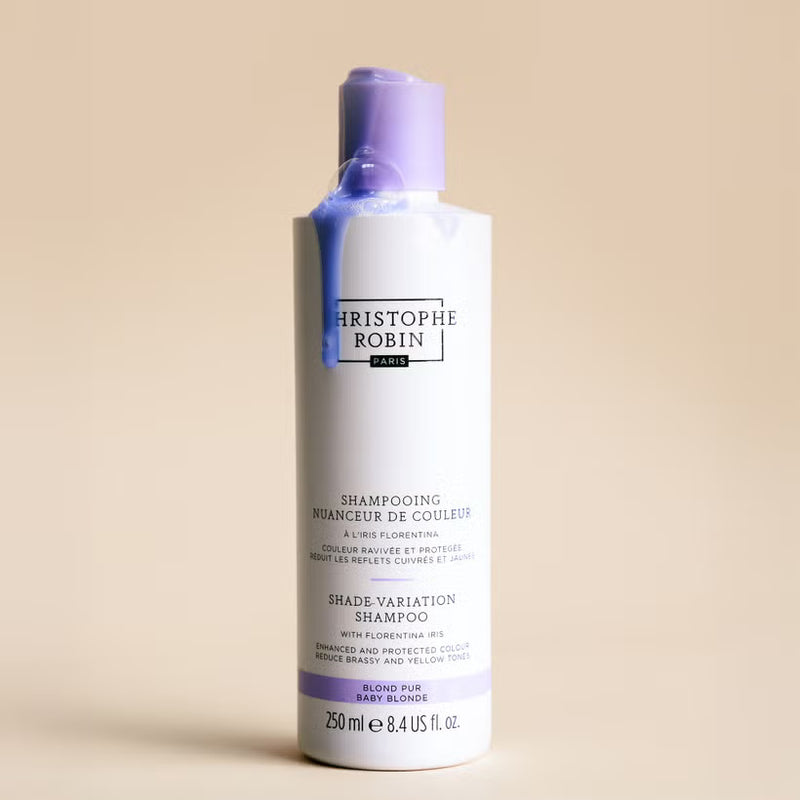 Bottle of Christophe Robin baby blonde shampoo on a beige background