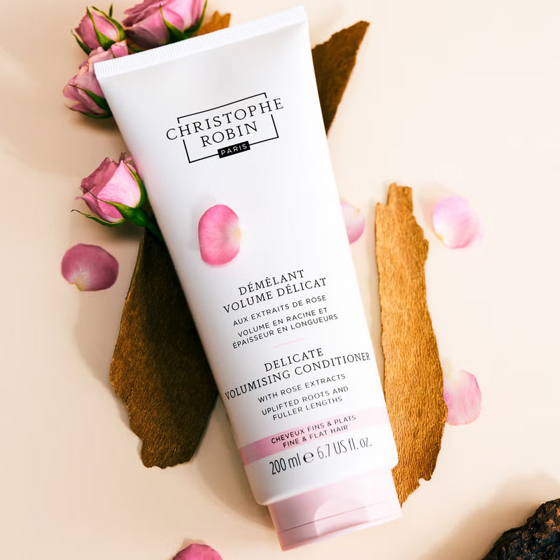 Christophe Robin delicate volumising conditioner with roses and petals on a beige background