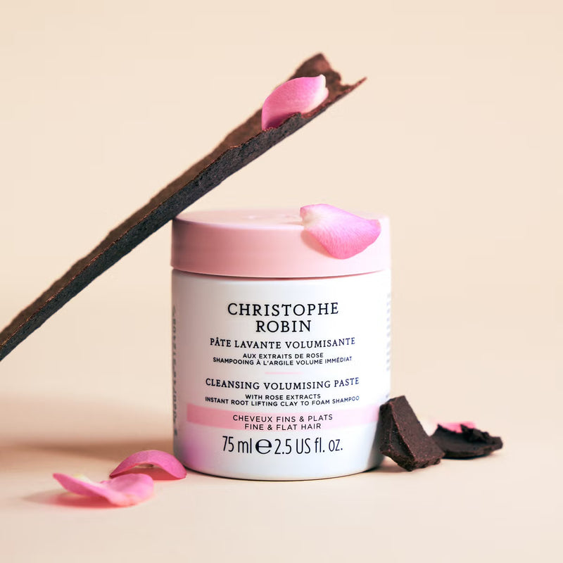 Cleansing volumising paste 75ml container with rose petals on a beige background