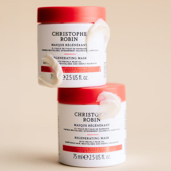Two containers of Christophe Robin regenerating mask on a beige background